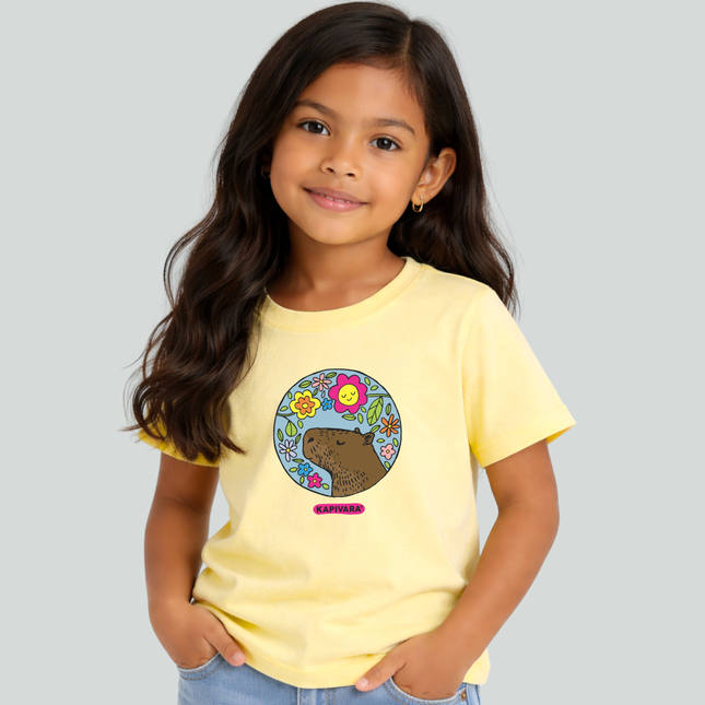 Menina usando camiseta infantil amarela com estampa capivara com flores coloridas