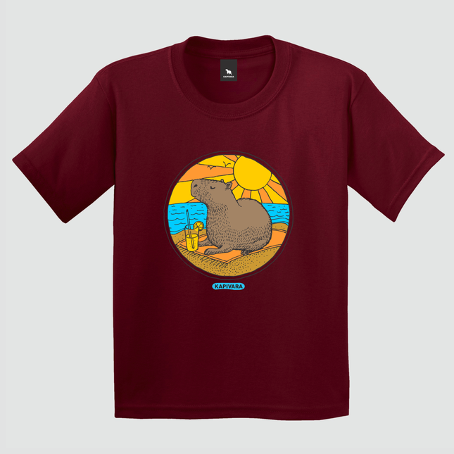 Camiseta infantil bordô com estampa de capivara na praia com sol e mar