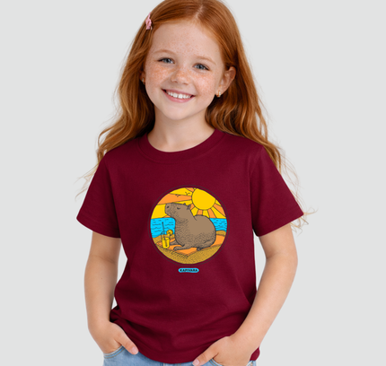 Menina usando camiseta infantil bordô com estampa capivara na praia