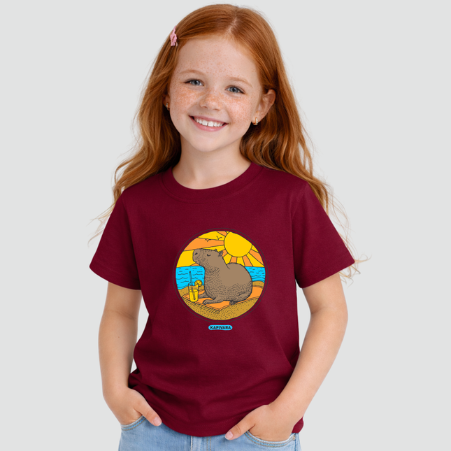 Menina usando camiseta infantil bordô com estampa capivara na praia