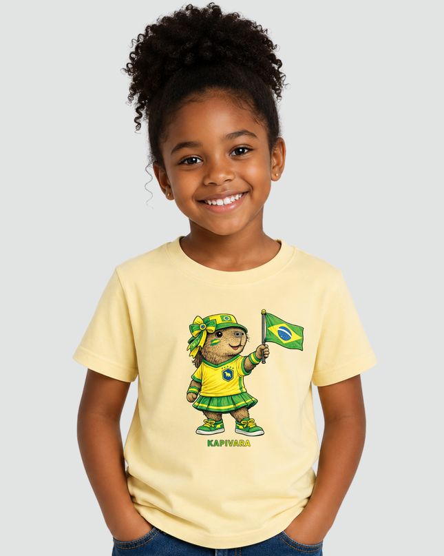 Menina usando camiseta infantil Capivara Torcedora Brasil Copa amarela com estampa de capivara segurando bandeira do Brasil