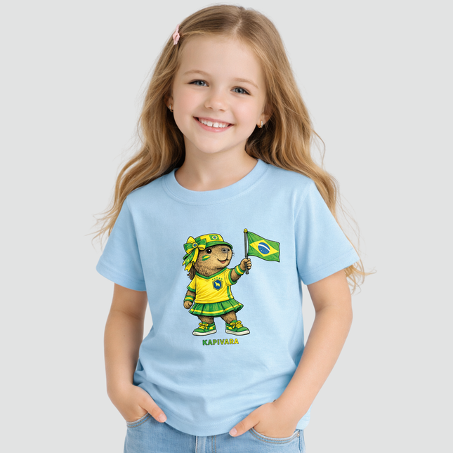Menina usando camiseta infantil Capivara Torcedora Brasil Copa azul com estampa de capivara segurando bandeira do Brasil